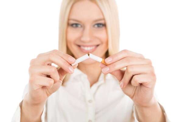 Quit smoking, young blonde woman breaking up a cigarette